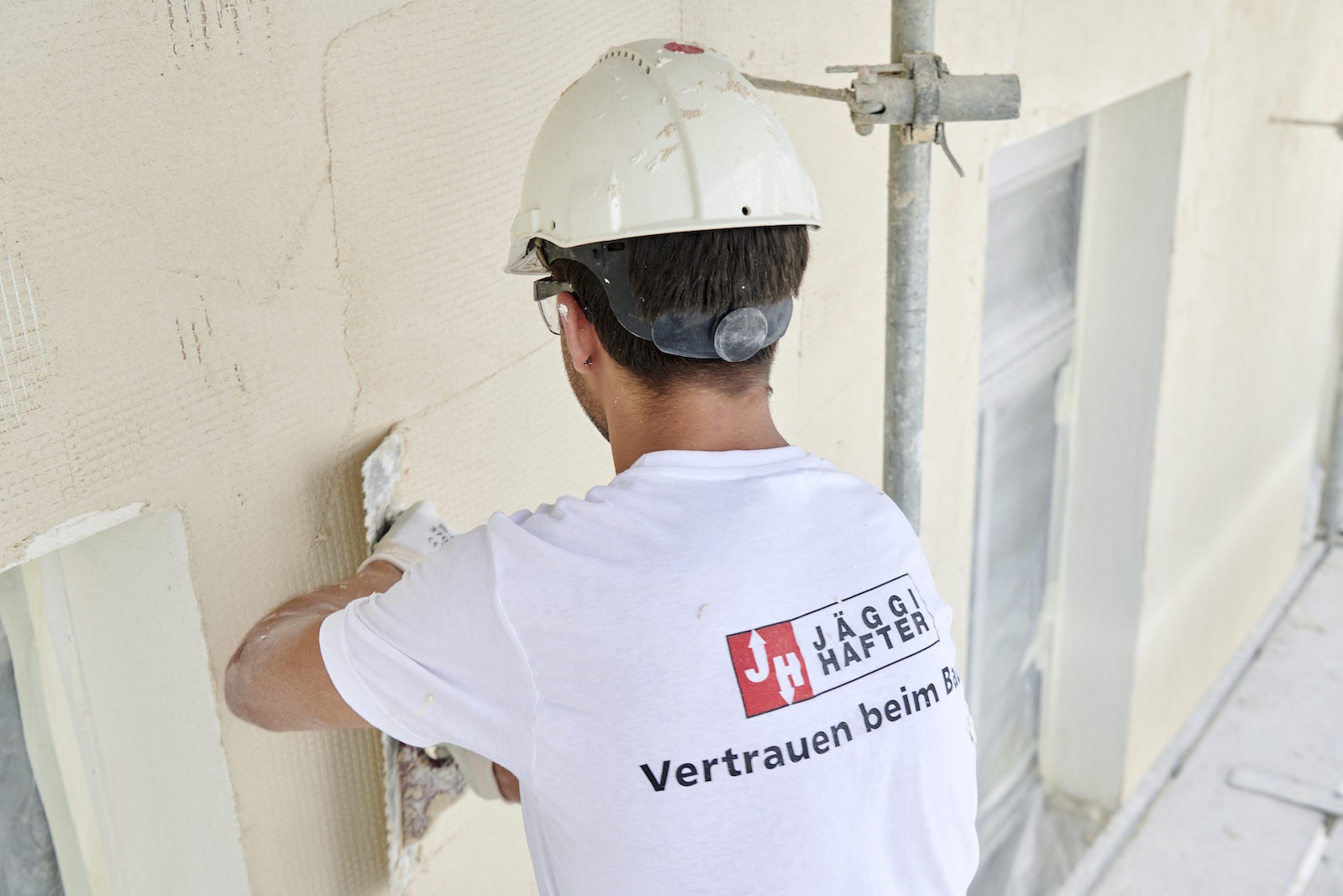 Handwerker verputzt im Aussenbereich eine Wand