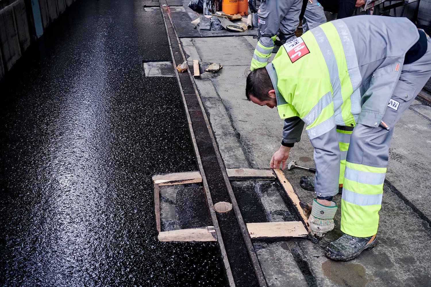 Mann legt Holzrahmen für Gussasphalt Aussparung