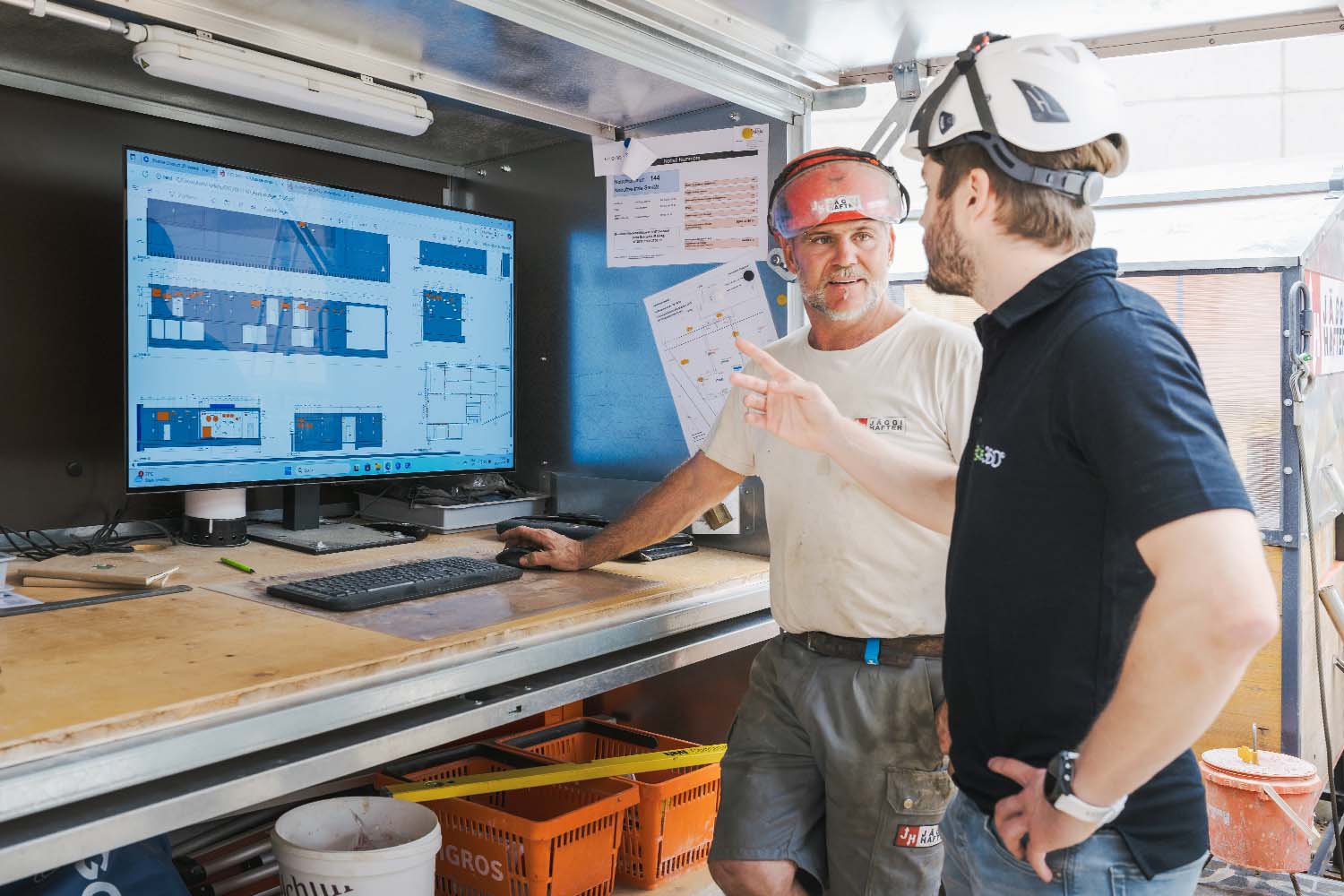 Bauleiter bei Besprechung mit BIM-Planung am Bildschirm